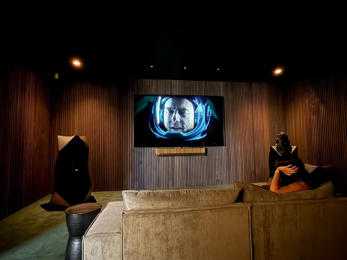 Dark slat panel walls around a TV in a home cinema room