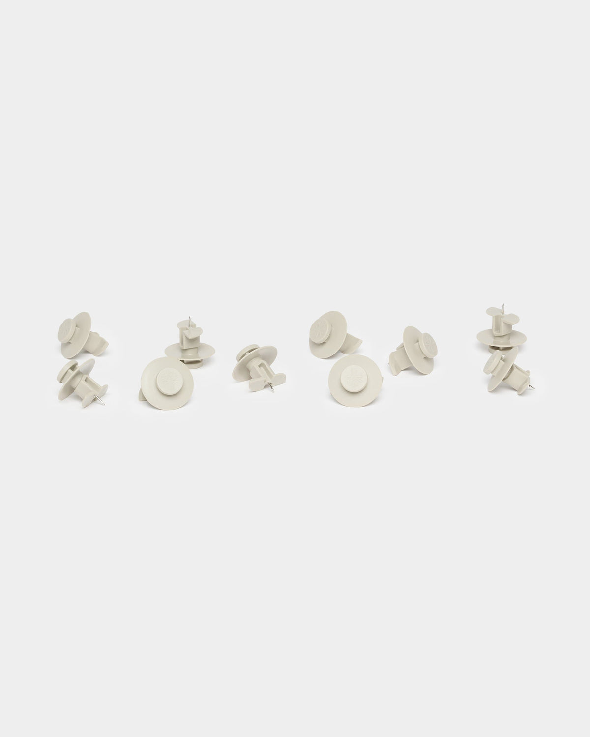 Ten beige Dupps loosely grouped on a white background