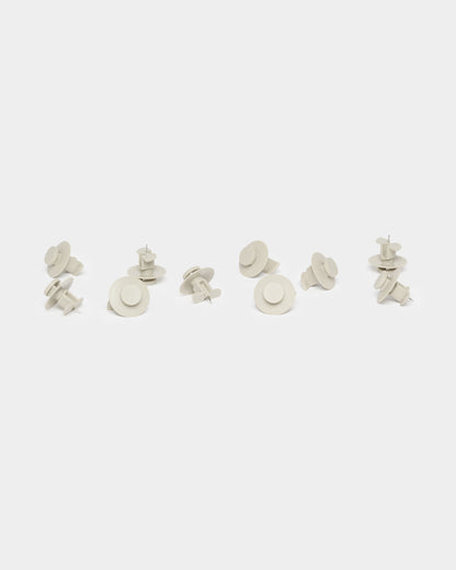 Ten beige Dupps loosely grouped on a white background